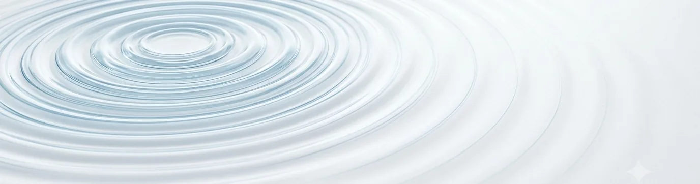 Concentric ripples spreading outward across a still pale-blue surface.