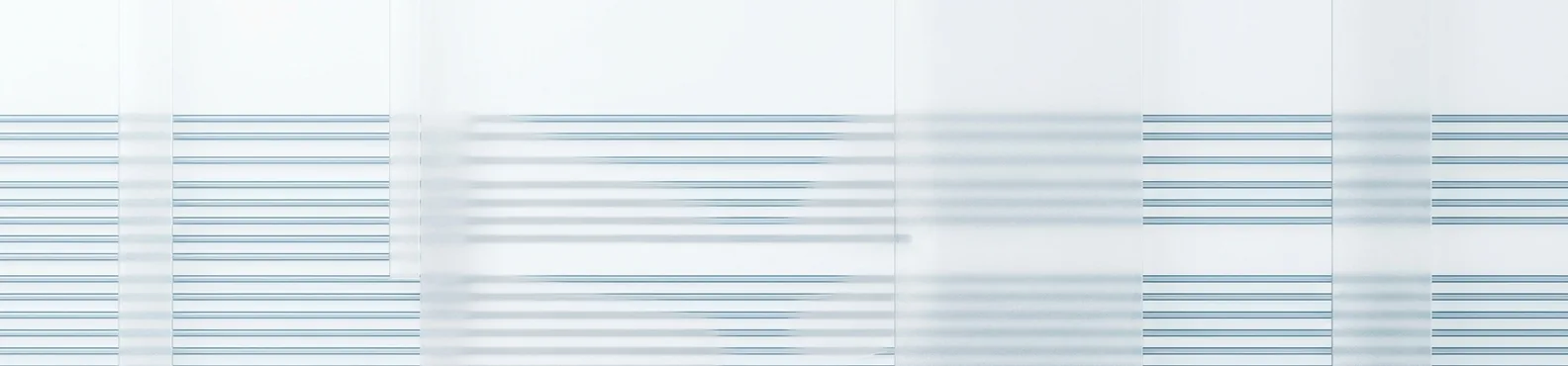 Fine horizontal rules of pale blue text ruled across overlapping paper panels.